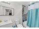 Bright bathroom with a white sink, toilet, and shower with teal and white curtain at 3043 Matipan Ave, North Charleston, SC 29405