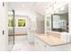 Bright bathroom featuring dual sinks, a window seat, and a glass-enclosed shower at 34 Eugenia Ave # B, Kiawah Island, SC 29455