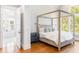 Cozy bedroom showcasing a four-poster bed, hardwood floors, and abundant natural light at 34 Eugenia Ave # B, Kiawah Island, SC 29455