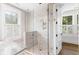 Modern walk-in shower with glass enclosure, pebble floor, and window providing natural light at 34 Eugenia Ave # B, Kiawah Island, SC 29455