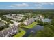 Scenic aerial view of a community with townhomes, a pond with fountain, and tennis courts surrounded by lush greenery at 3588 Bagley Dr, Mount Pleasant, SC 29466
