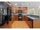 A kitchen with wood cabinets, stone countertops, stainless steel appliances, and hardwood flooring at 3588 Bagley Dr, Mount Pleasant, SC 29466