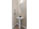 Stylish pedestal sink in powder room with round mirror, bronze fixtures, and neutral decor at 3588 Bagley Dr, Mount Pleasant, SC 29466