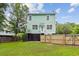 Backyard features a green home with white trim, wooden fence, green grass, and a hammock at 3636 Purple Martin Ct, Mount Pleasant, SC 29466