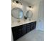 Bathroom featuring double vanity, white countertop, black cabinets, round mirrors, and modern lighting at 3636 Purple Martin Ct, Mount Pleasant, SC 29466