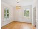 Elegant dining room with wood floors, wainscoting, two windows, and modern chandelier at 3636 Purple Martin Ct, Mount Pleasant, SC 29466