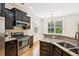 Kitchen with dark cabinets, stainless steel appliances, granite countertops, and bright windows at 3636 Purple Martin Ct, Mount Pleasant, SC 29466