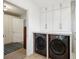 Laundry room featuring a washer and dryer, storage cabinets, and tile floors at 38 Colleton Dr, Charleston, SC 29407