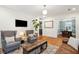 Open concept living room featuring hardwood floors, gray accent chairs, and natural light from the windows at 38 Colleton Dr, Charleston, SC 29407