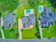 Aerial view of three homes with pools, lush landscaping, and well-maintained lawns in a suburban neighborhood at 4246 Club Course Dr, North Charleston, SC 29420