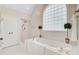 Bright bathroom boasting a large arched window above a soaking tub with gold fixtures and decorative greenery at 4246 Club Course Dr, North Charleston, SC 29420