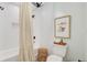 Full bathroom with toilet, art, and shower with neutral colored shower curtain at 4246 Club Course Dr, North Charleston, SC 29420