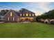 Stately brick home with well-maintained lawn, covered front porch, black shutters, and professional landscaping at 4246 Club Course Dr, North Charleston, SC 29420