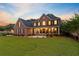 Beautiful two-story brick home featuring a covered front porch, well-manicured lawn, and professional landscaping at 4246 Club Course Dr, North Charleston, SC 29420