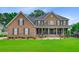 Beautiful two-story brick home featuring a manicured lawn and shrubs at 4246 Club Course Dr, North Charleston, SC 29420