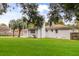Well-kept backyard with a white brick house, featuring a chimney and a detached garage at 4939 Ashby Ave, North Charleston, SC 29405