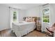 Airy bedroom with neutral tones, a decorative headboard, and natural light from two windows at 4939 Ashby Ave, North Charleston, SC 29405