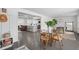 Open-concept dining room with gray floors, a glass top table, and a seamless view into the adjacent living spaces at 4939 Ashby Ave, North Charleston, SC 29405