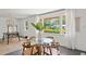 Dining room with a glass table, wooden chairs, and large windows with views of the lush green exterior at 4939 Ashby Ave, North Charleston, SC 29405