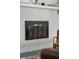 Close-up of the painted white brick fireplace with glass front firebox at 4939 Ashby Ave, North Charleston, SC 29405