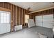 Spacious unfinished garage interior with exposed framework, a rolling garage door, and a side door at 4939 Ashby Ave, North Charleston, SC 29405