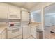 Cozy kitchen featuring white appliances, cabinets, and a view into a nearby living area at 516 Arlington Dr # B4, Charleston, SC 29414