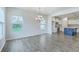 Bright dining area with grey floors, large windows, and a view into the kitchen with a blue island at 523 Purple Finch Rd, Summerville, SC 29486