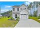 Charming two-story home features a clean white facade, attached garage, and well-manicured landscaping at 523 Purple Finch Rd, Summerville, SC 29486