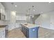 Well-equipped kitchen with a large island, quartz countertops, stainless steel appliances, and wood-look flooring at 523 Purple Finch Rd, Summerville, SC 29486
