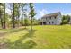 Spacious backyard featuring a two-story house, mature trees, green grass and play set at 5541 Alpine Dr, Summerville, SC 29483