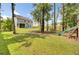 Lush backyard with a house, trees, green grass, and play set at 5541 Alpine Dr, Summerville, SC 29483