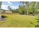 Spacious backyard featuring lush green grass, a wooden fence and mature trees, perfect for outdoor activities at 5541 Alpine Dr, Summerville, SC 29483