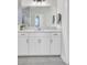 Bright bathroom featuring a white vanity with double sinks, modern fixtures, and gray floor tiles at 5541 Alpine Dr, Summerville, SC 29483