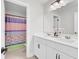 Bright bathroom featuring a white vanity with double sinks, modern fixtures, and colorful shower curtain at 5541 Alpine Dr, Summerville, SC 29483