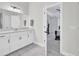 Bright bathroom featuring a white vanity with double sinks, modern fixtures, and a view into an adjacent bedroom at 5541 Alpine Dr, Summerville, SC 29483