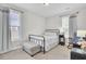 Bright bedroom featuring a black metal bed frame, two windows, neutral carpet and gray upholstered bench at 5541 Alpine Dr, Summerville, SC 29483