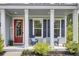 Inviting front porch with stylish seating, a charming red door, and tasteful decor, offering a cozy welcome at 5541 Alpine Dr, Summerville, SC 29483