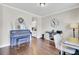 Bright living room with hardwood floors, a stylish piano, and views into the adjacent kitchen area at 5541 Alpine Dr, Summerville, SC 29483