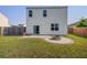 This backyard showcases a lovely stone fire pit, fenced yard, and sliding glass door access at 596 Wayton Cir, Moncks Corner, SC 29461