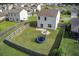 Aerial view of a fenced-in backyard featuring a well-maintained lawn, fire pit area, and a trampoline at 596 Wayton Cir, Moncks Corner, SC 29461