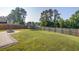 Spacious backyard with a manicured lawn, fire pit, and trampoline, fully enclosed by a wooden privacy fence at 596 Wayton Cir, Moncks Corner, SC 29461