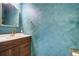 Stylish powder room with a modern wood vanity, gold fixtures, arched mirror, and eye-catching textured blue walls at 596 Wayton Cir, Moncks Corner, SC 29461