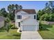 Charming two-story home featuring a well-manicured lawn, a two-car garage, and classic architectural details at 596 Wayton Cir, Moncks Corner, SC 29461