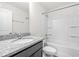 Bathroom with granite countertop, framed mirror, shower with tile surround and built-in shelves at 7787 Montview Rd, North Charleston, SC 29418