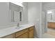 Bright bathroom with wooden vanity, white countertops, large mirror, and tile flooring at 800 Enclave Ter, Summerville, SC 29483