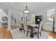 Elegant dining room featuring hardwood floors, decorative rug, modern chandelier and staircase access at 800 Enclave Ter, Summerville, SC 29483
