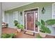 Inviting front porch with a wooden door, swing, and decorative plants at 800 Enclave Ter, Summerville, SC 29483