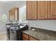 Functional laundry room with modern washer and dryer, custom cabinets, and granite countertop at 800 Enclave Ter, Summerville, SC 29483
