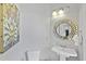 Stylish powder room with unique round mirror, modern vanity, and decorative artwork at 800 Enclave Ter, Summerville, SC 29483