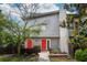 Charming two-story home boasts vibrant red doors, complemented by a lush, landscaped front yard and mature trees at 801 Ventura Pl, Mount Pleasant, SC 29464